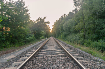 Fototapeta premium Railroad in the forest at sunset.