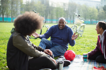 Happy father and teen kids in sunny urban park