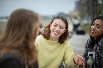 Happy young women friends talking