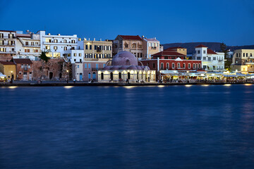 Fototapeta na wymiar Historic mosque and houses in the evening in the port of Chania city