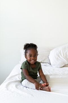 A child smiles on a bed