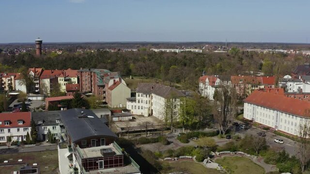 The drone flies sideways over the roofs of the town of Wittenberge in Brandenburg Germany. The sun is shining and the sky is blue.