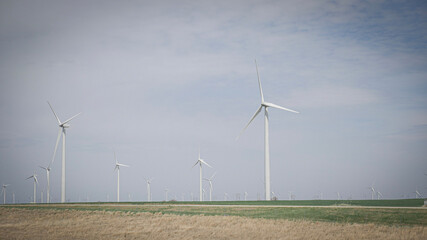Clean green energy windmill turbine farm on rolling hills of Kansas