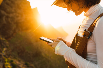 Woman smartphone on landscape sky at sunset