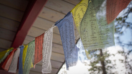 Buddhist prayer flags wave in the breeze on a sunny mountainside
