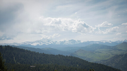 Beautiful view of forest hills and snow covered mountain peaks in Colorado