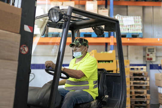 Hispanic man volunteer using a forklift 