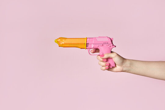 Woman holding gun with condom