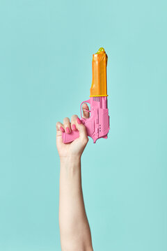 Woman holding pink gun with condom