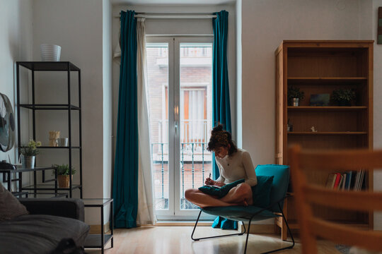 Young woman noting down at home