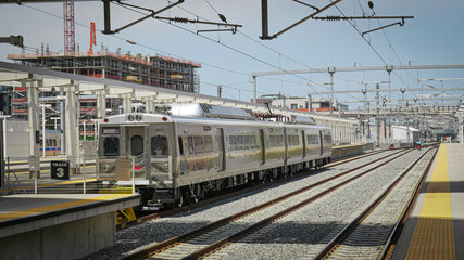 Shiny silver metro subway cars sit on railroad track outside Union Station in Denver, Colorado
