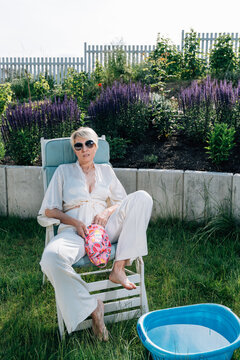 A Mature Woman Wearing White Clothes And Sunglasses 