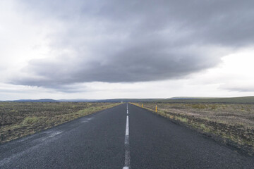 Infinite long and solitude asphlat road in a cloudy day in Iceland