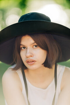 summer portrait of young woman with black hat