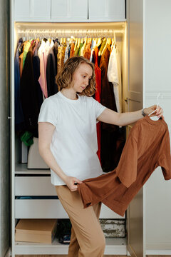 Woman with t-short near open wardrobe