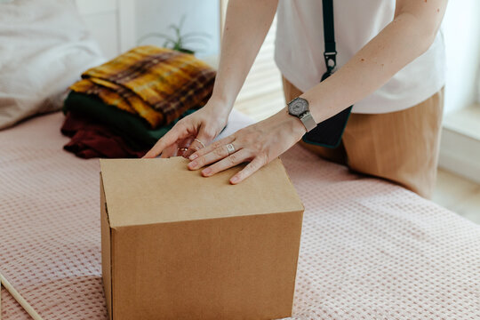 Woman packing wear in box for delivery