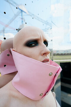 Fashion model with alopecia posing in pink collar 