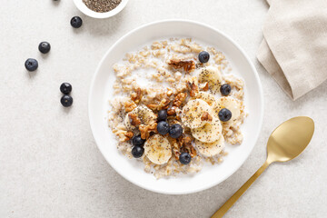 Oatmeal bowl. Oat porridge with banana, blueberry, walnut, chia seeds and almond milk for healthy breakfast or lunch. Healthy food, diet. Top view. - 463696826