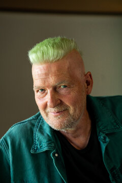 Portrait of cool happy senior man with green mohawk 