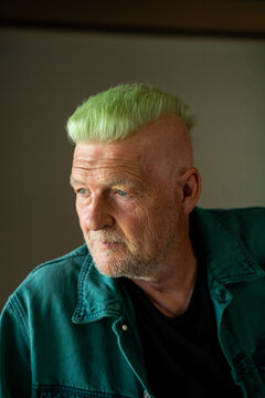 Portrait of cool senior man with green mohawk 