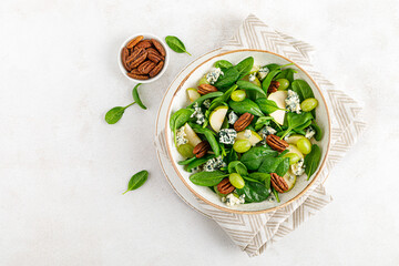 Salad of spinach, pear, grape, pecan and gorgonzola cheese with lemon dressing. Healthy food, diet....