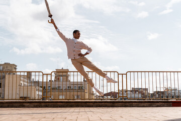 Ballet dancer in the air with an umbrela at rooftop 