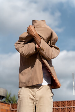 Fashionable man covering himself with his jacket
