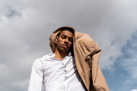 Black man posing at camera with his blazer around