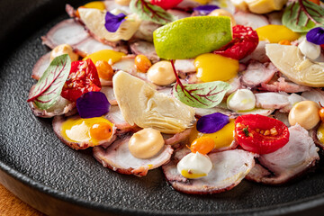 Fototapeta na wymiar Octopus Carpaccio with sauce and vegetables