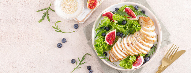 Chicken breast baked and fresh salad of lettuce, arugula, blueberry and figs. Healthy diet food. Top view. Banner.