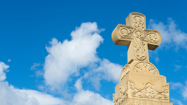 old church cross. stone cross on a background of blue sky