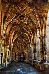 Passageway with columns and ceiling in gothic style on a building of Leon. An ancient town on countryside of Spain. Oil paint filter.