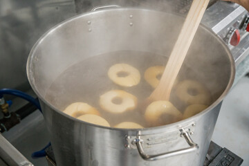 boiling bagels - raw dough formed into shape of bagels