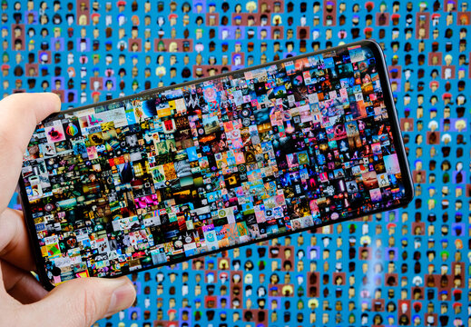 Two the most expensive NFT artworks. Concept. Beeple's "Everydays &mdash; The First 5000 Days" seen on smartphone and CryptoPunks pixel art on blurred background. Stafford, United Kingdom, October 17, 2021.