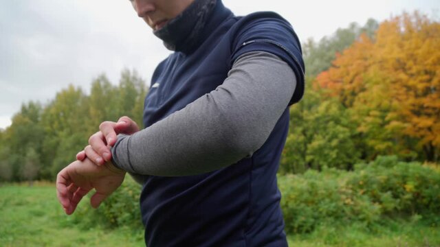 Close up shot of an amateur athlete using his sports watch to measure the running time. Modern technologies in sport industry for any people 