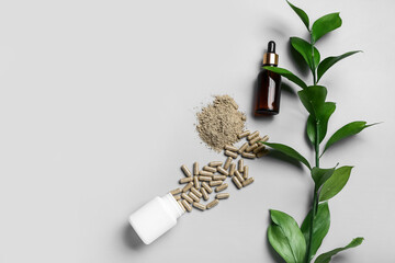 Composition with pills and green branch on light background