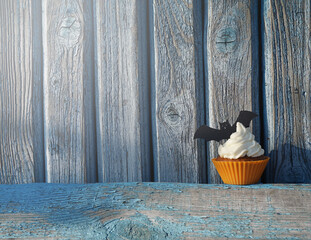 Obraz na płótnie Canvas pumpkin muffins with halloween decoration on aged blue wooden background, copy space