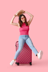 Fototapeta na wymiar Young woman with suitcase on color background
