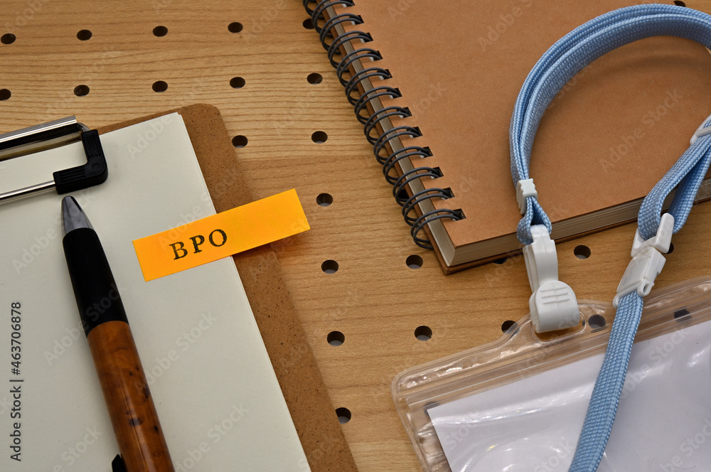 Poster there is a sticky note with the letters bpo stamped on the edge of a clipboard placed along with a n