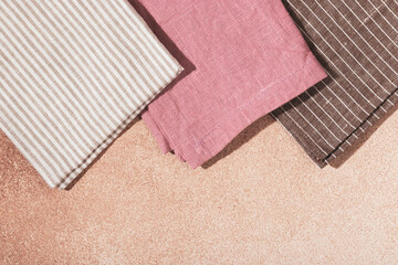 Stack of colored cloth serving napkins on beige plastered background