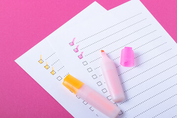 Check list with pink and orange marked points and markers on pink background