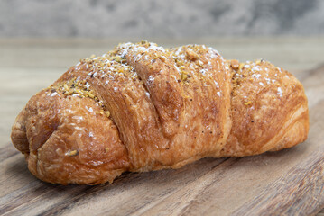 Pistachio nutella breakfast croissant served fresh from the oven on a wooden platter