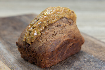 Freshly baked loaf of banana bread slathered with pistachio butter and served on a wooden platter