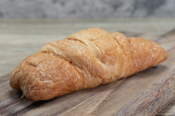 Butter breakfast croissant served fresh from the oven on a wooden platter