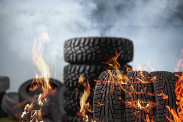 Tyres are on fire. Burning old tyres on recycling landfill. Smoke from tires fire.