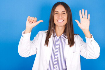 Young european doctor woman on blue background showing and pointing up with fingers number six while smiling confident and happy.