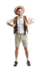 Handsome young man in traditional German clothes on white background