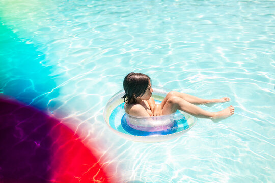 Cold teenager floating on tube