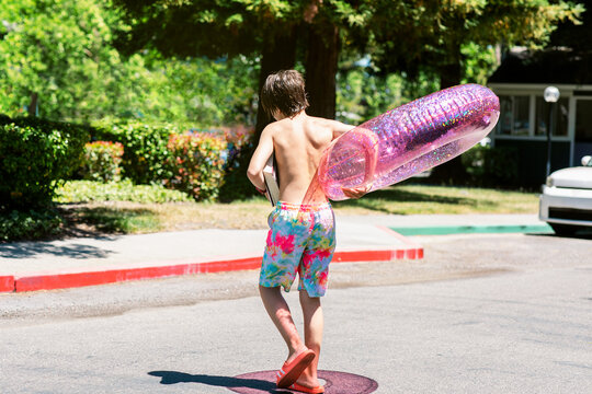 Teenager with ring float crossing road