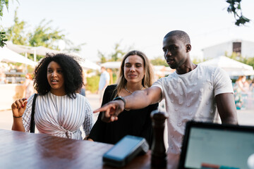 Multiracial friends ordering food in park